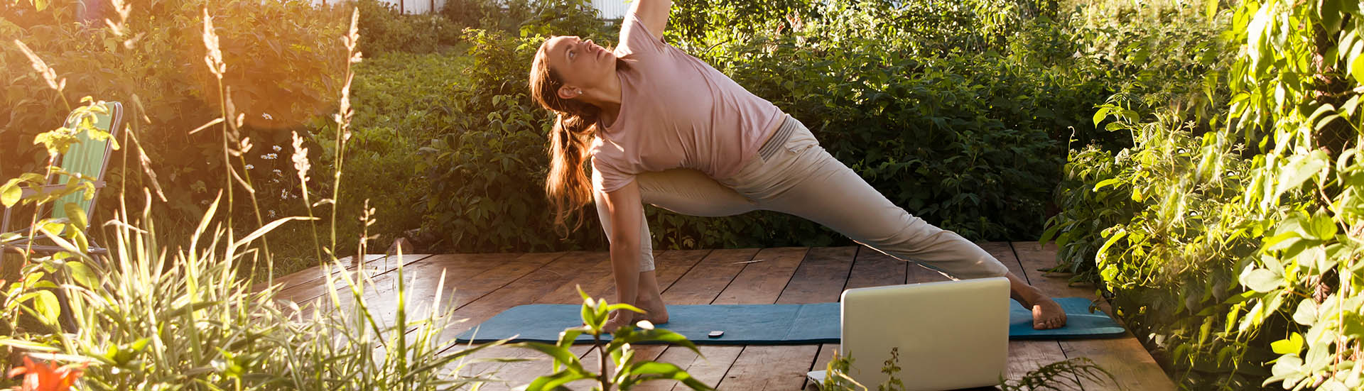 Frau macht im Garten Yoga
